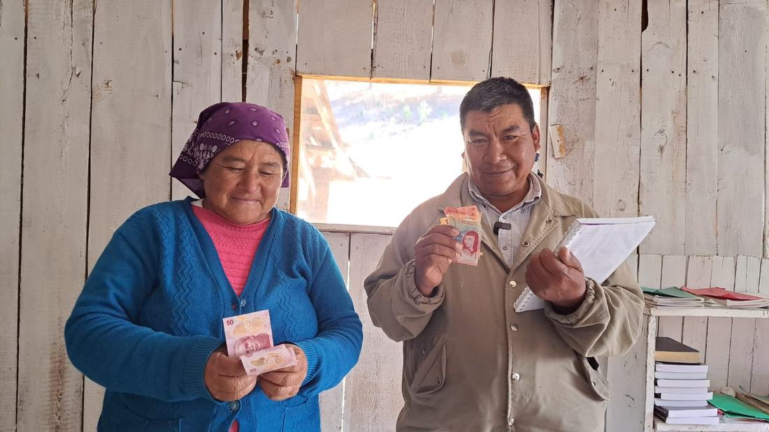 Gregorio junto a otra integrante de su grupo de ahorro, mostrando sus ahorros